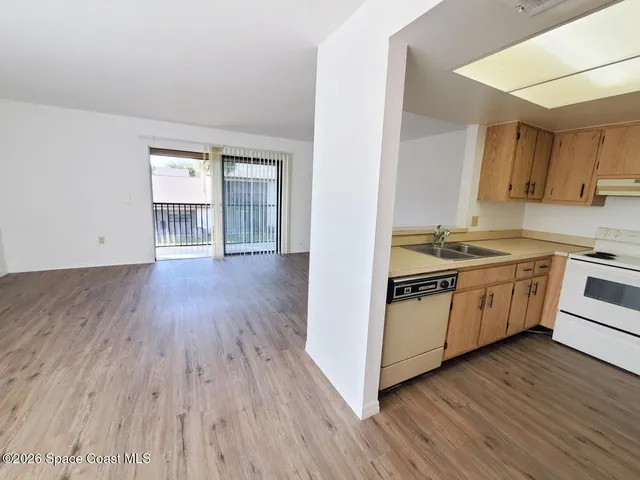 a kitchen with wooden floors and white appliances