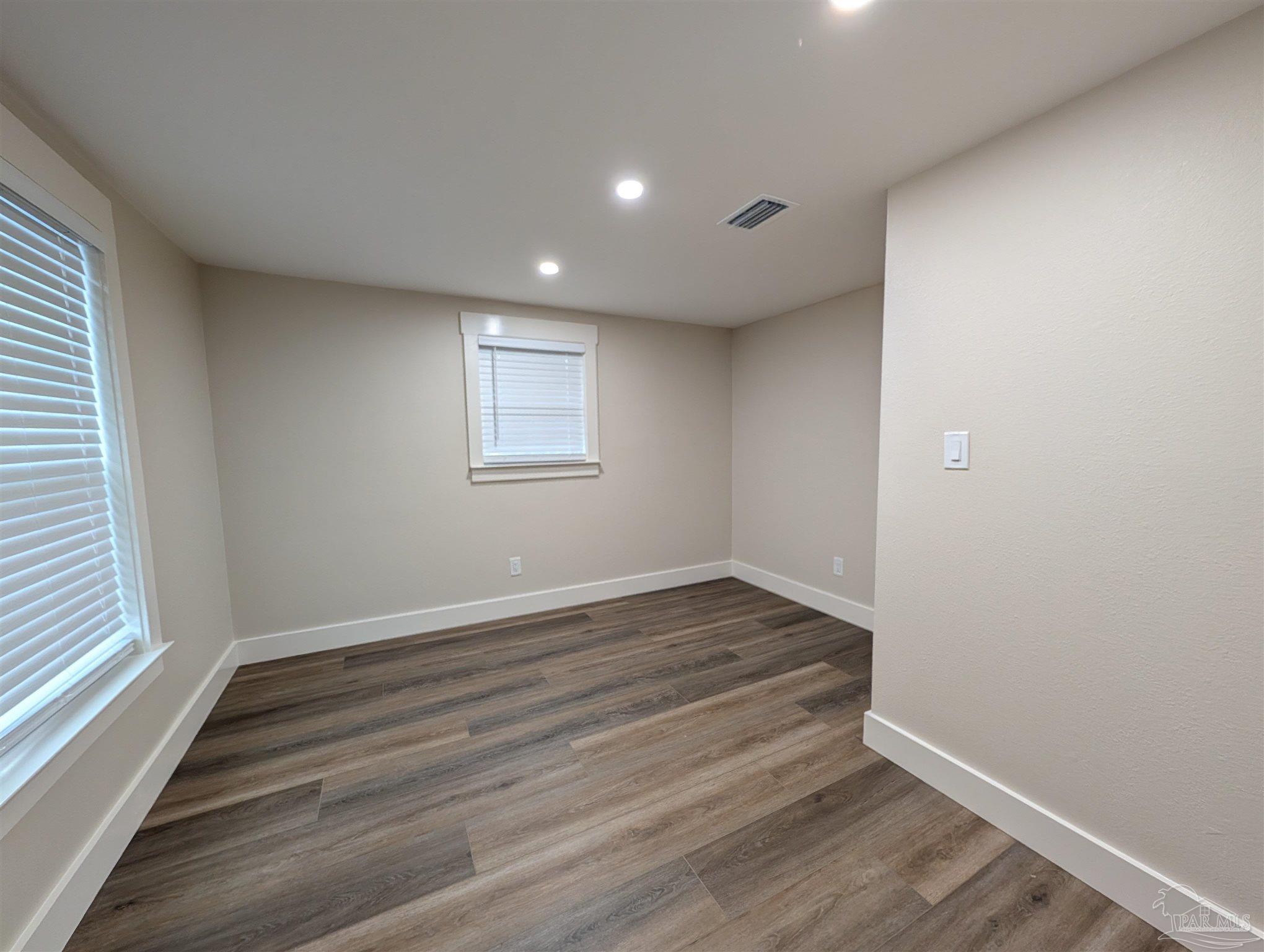 222 Santa Rosa Road Cantonment, FL 32533 - Photo 30 of 48 an empty room with wooden floor and windows