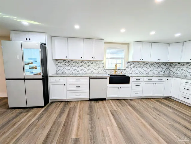 a kitchen with stainless steel appliances white cabinets and a refrigerator