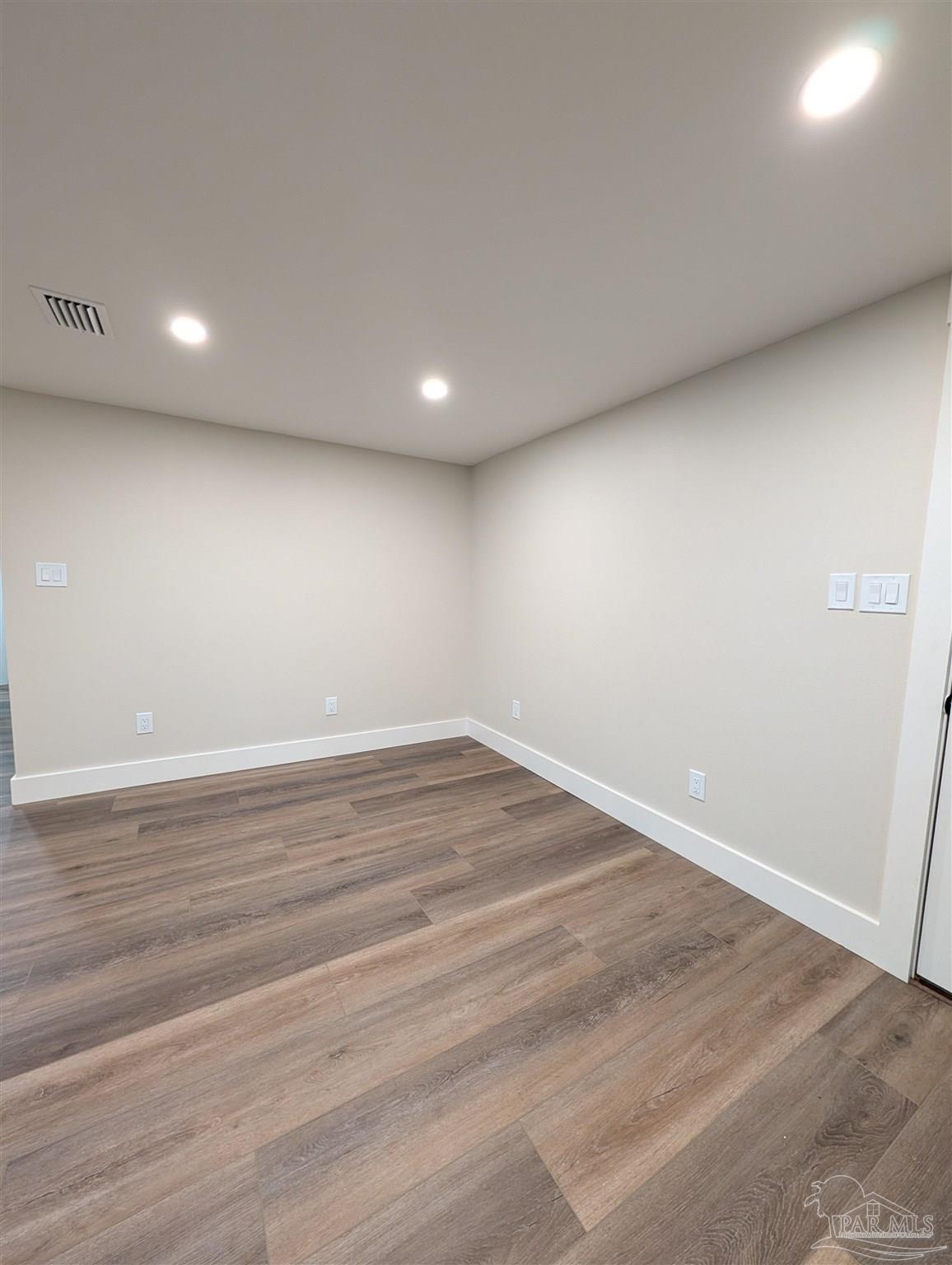222 Santa Rosa Road Cantonment, FL 32533 - Photo 10 of 48 an empty room with wooden floor and windows