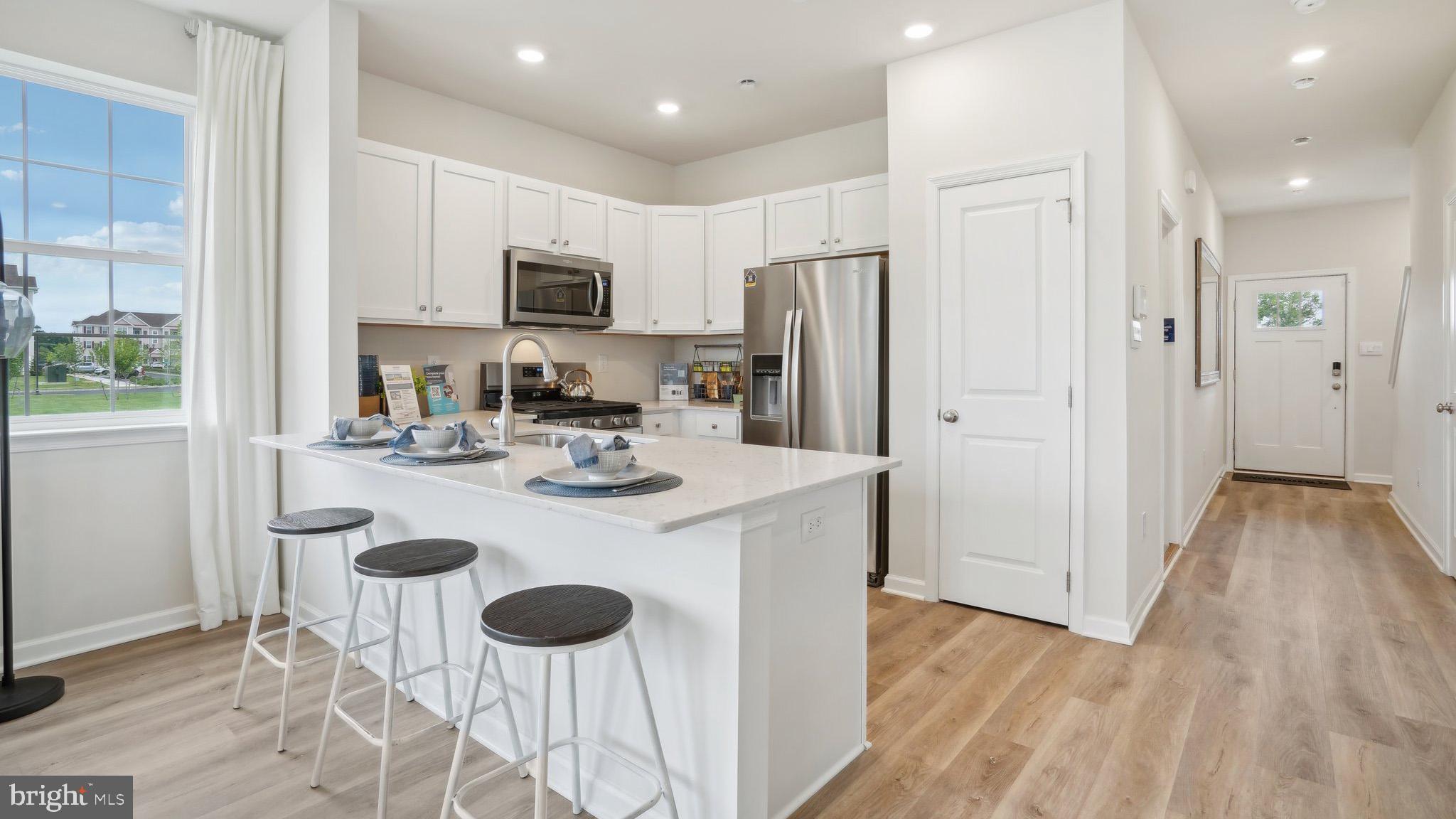 7 Eleanor Lane Roosevelt, NJ 08555 - Photo 2 of 19 a kitchen with stainless steel appliances granite countertop a refrigerator a stove a sink and a dining table with wooden floor
