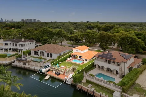 an aerial view of residential houses with outdoor space and lake view