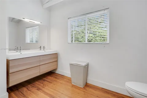 a bathroom with a sink a toilet and a window