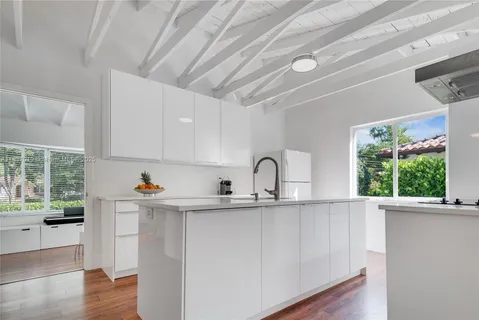 a kitchen with stainless steel appliances a sink window and cabinets