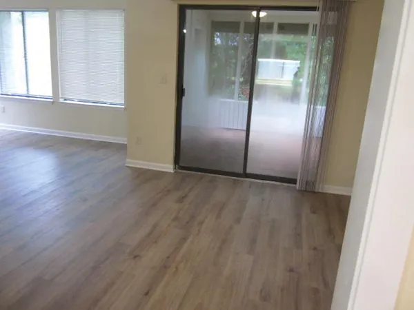 an empty room with wooden floor and entrance