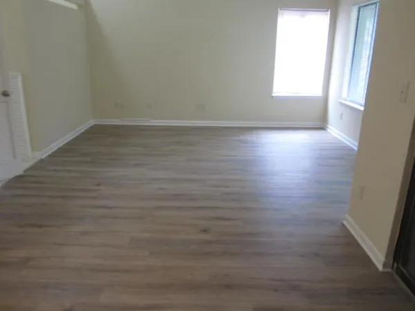 an empty room with wooden floor and mirror