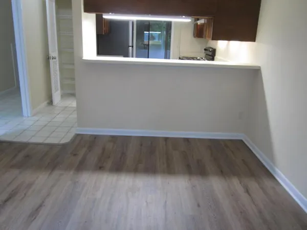 a view of empty room with wooden floor
