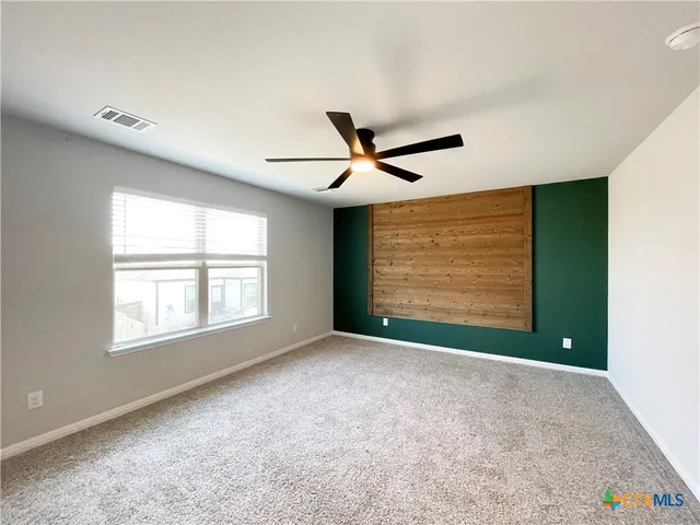 a bedroom with a bed a window and mirror