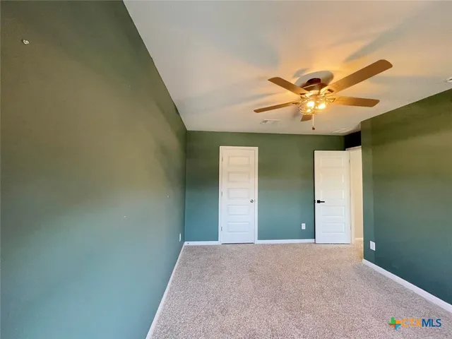 a view of a livingroom with a chandelier fan and a window