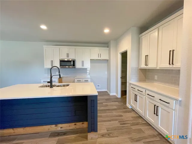 a kitchen with stainless steel appliances sink stove refrigerator and cabinets