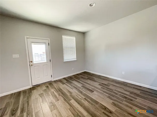 a view of empty room with wooden floor