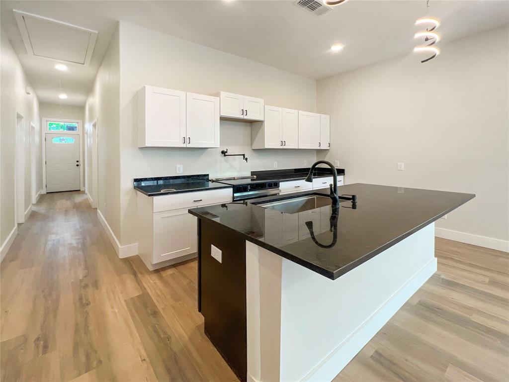 4006 Coolidge Street Dallas, TX 75215 - Photo 7 of 27 a kitchen with stainless steel appliances granite countertop a sink a stove and a wooden floors