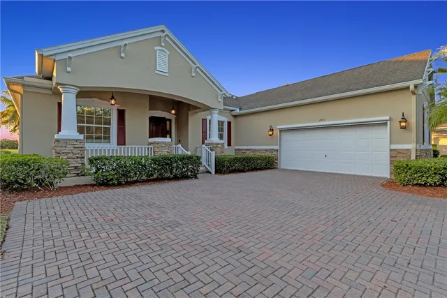a front view of house with yard and trees in the background
