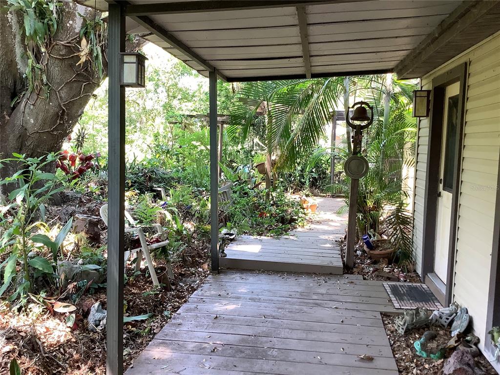16921 Crawley Road Odessa, FL 33556 - Photo 3 of 33 a view of porch with large trees and plants