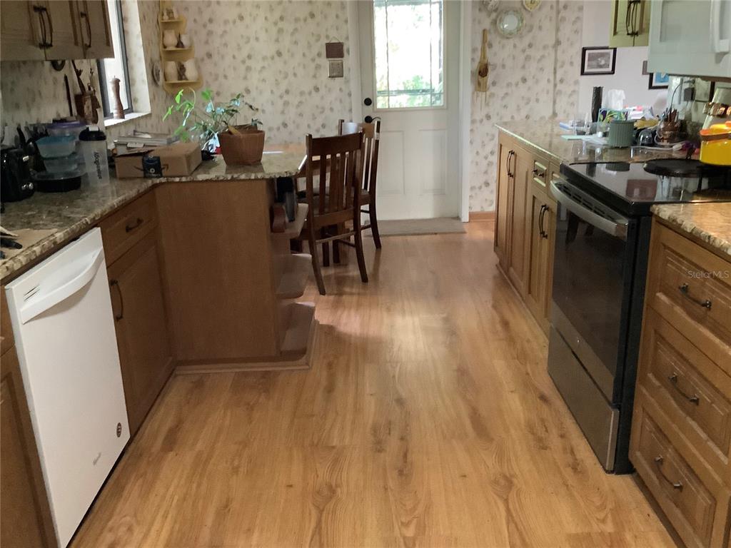 16921 Crawley Road Odessa, FL 33556 - Photo 4 of 33 a kitchen with wooden floors and glass cabinets