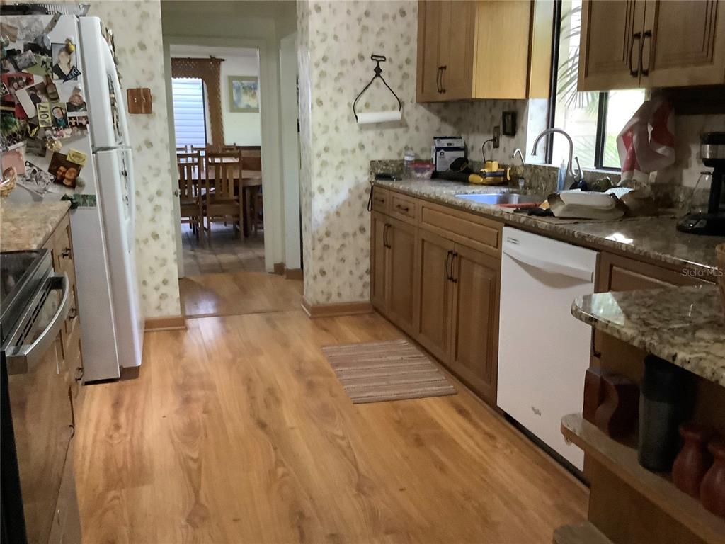 16921 Crawley Road Odessa, FL 33556 - Photo 6 of 33 a kitchen with stainless steel appliances granite countertop a sink stove and refrigerator