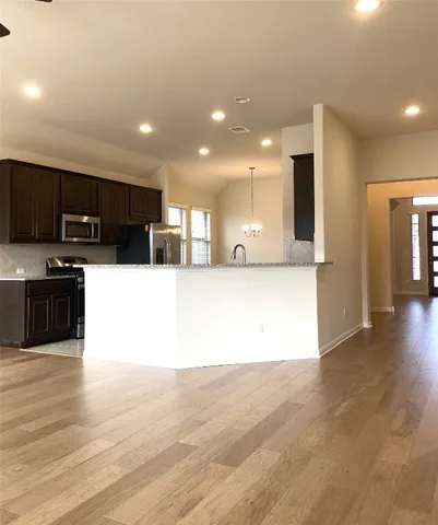 a kitchen with granite countertop a refrigerator and a sink