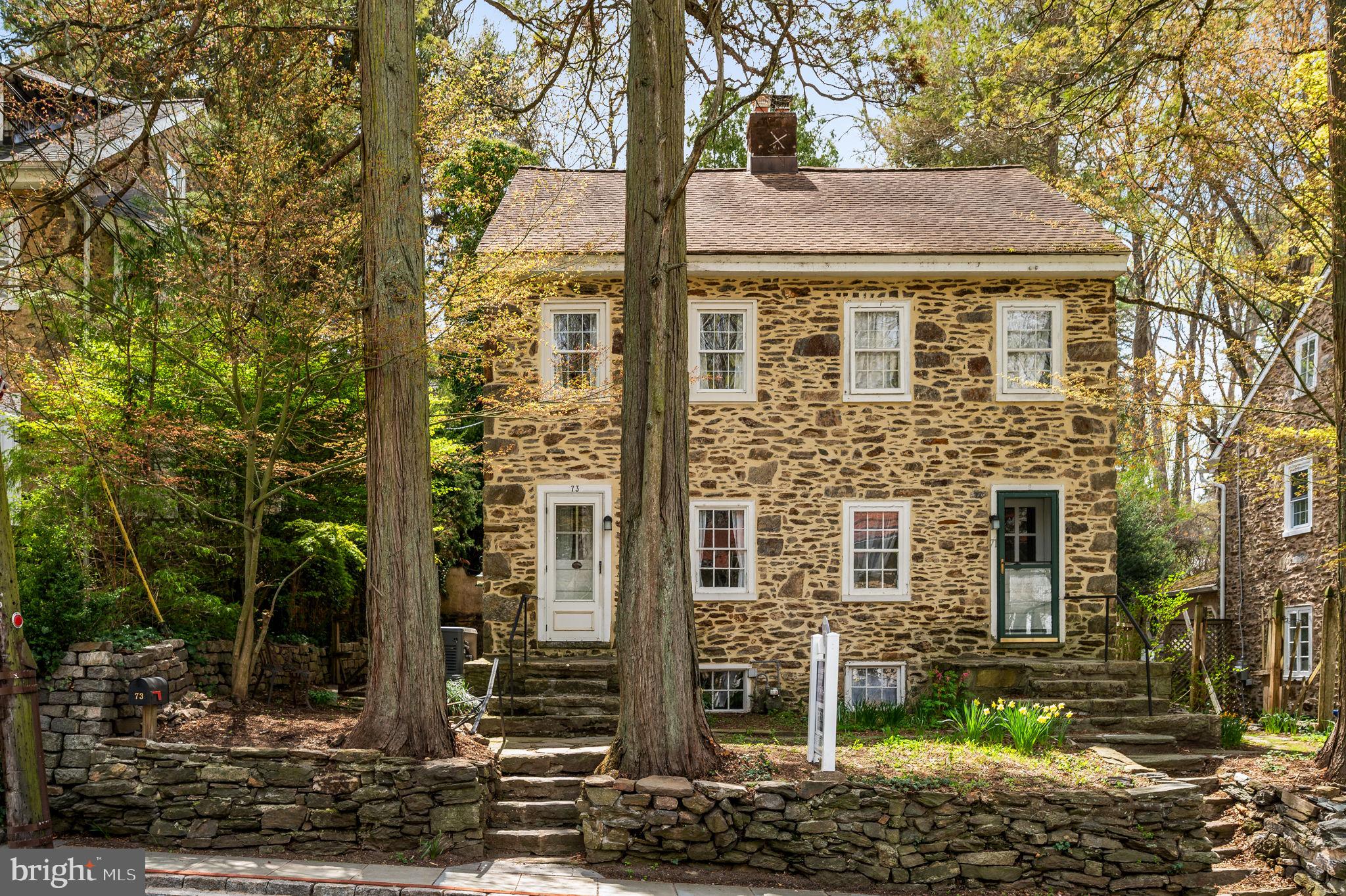 a front view of a house with a tree