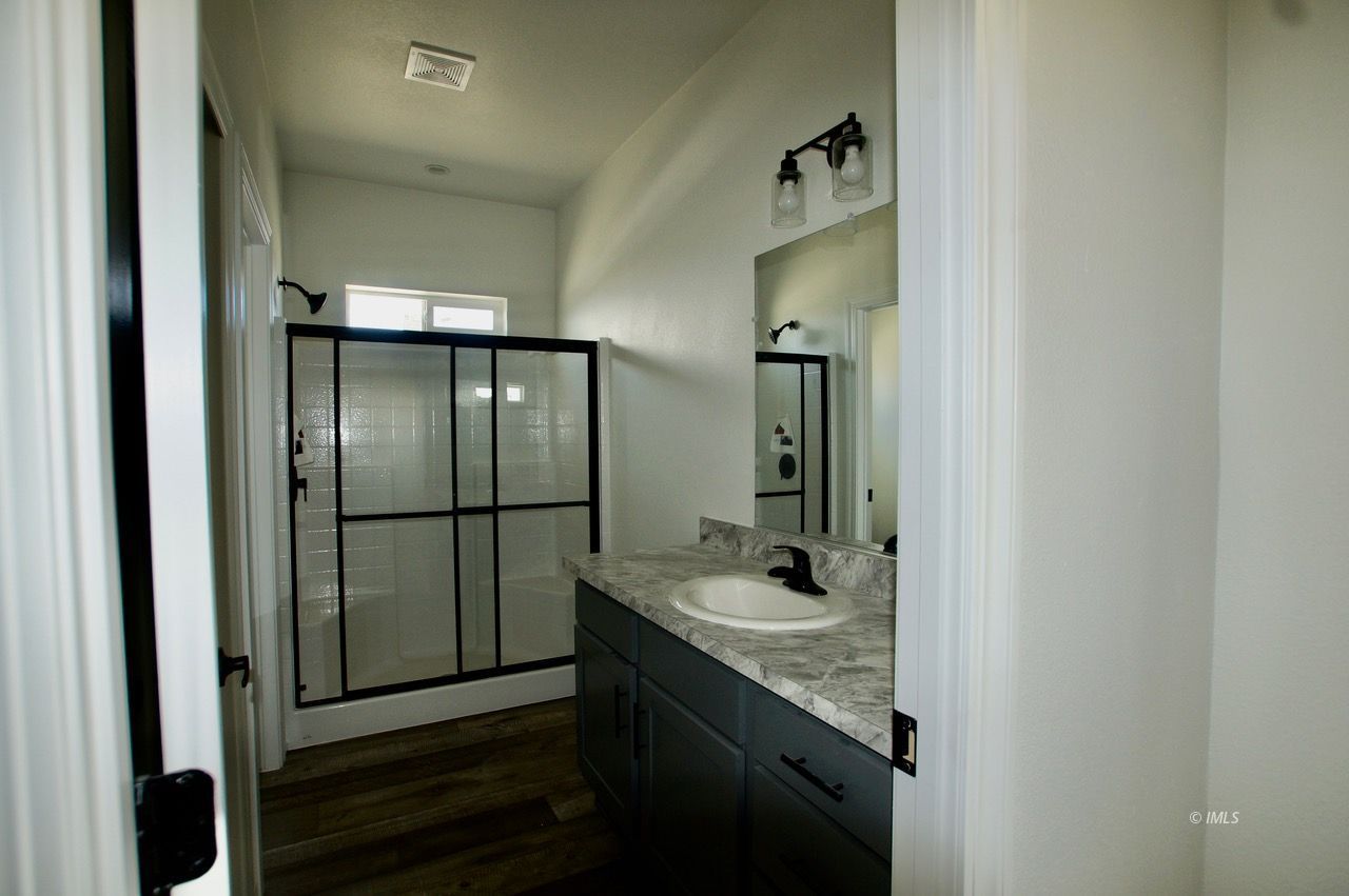 196 Tuolumne Road Bishop, CA 93514 - Photo 18 of 28 a bathroom with a granite countertop sink and a mirror