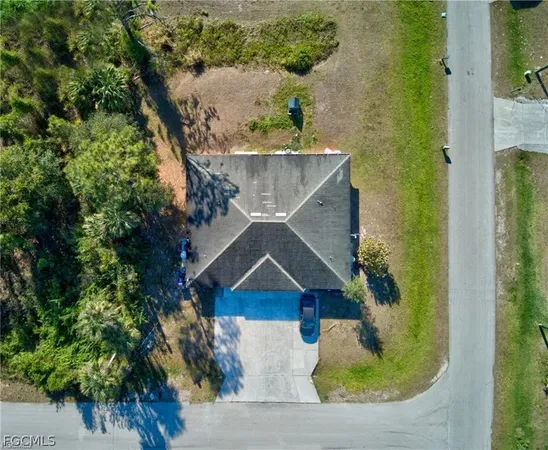 an aerial view of a house with a yard wooden table and chairs
