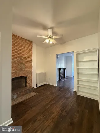 a view of an empty room with a fireplace and a window