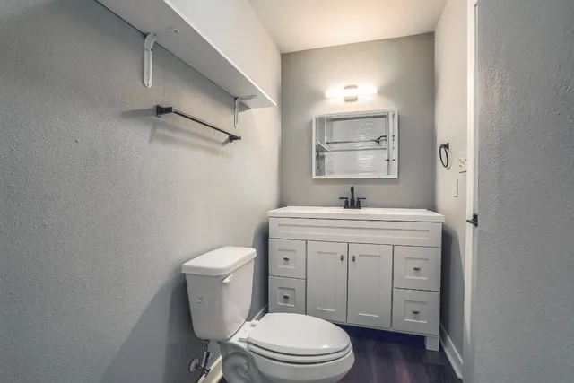 a bathroom with a toilet a sink and mirror