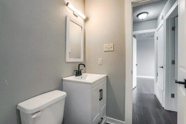 a bathroom with a toilet a sink and mirror