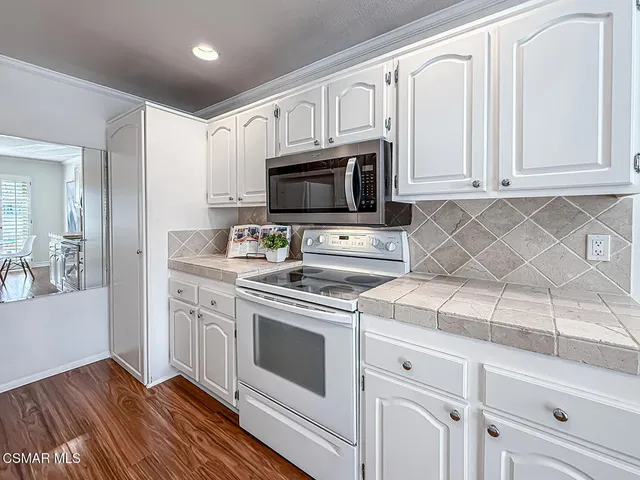 a kitchen with white cabinets stainless steel appliances and sink