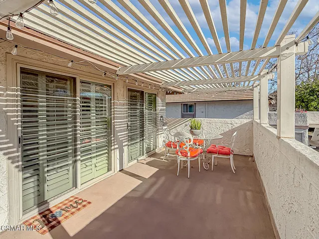 a view of a patio with table and chairs with wooden floor and fence