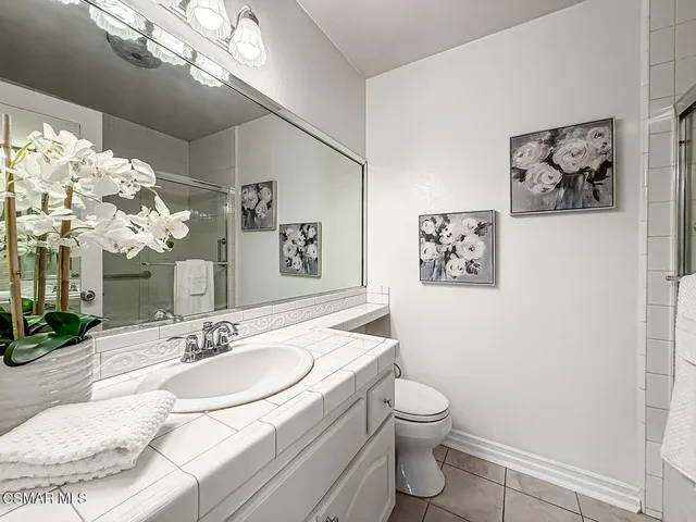 a bathroom with a granite countertop sink a toilet and a mirror