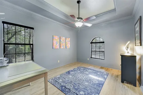 a view of an empty room with a window and ceiling fan