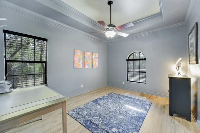 a view of an empty room with a window and ceiling fan
