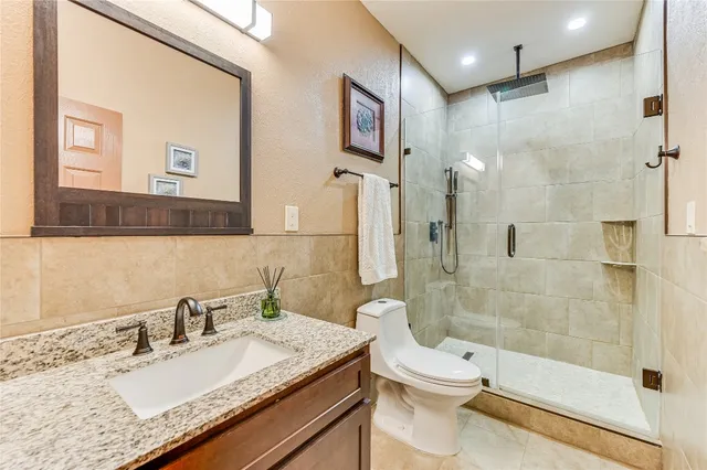 a bathroom with a granite countertop sink toilet and shower