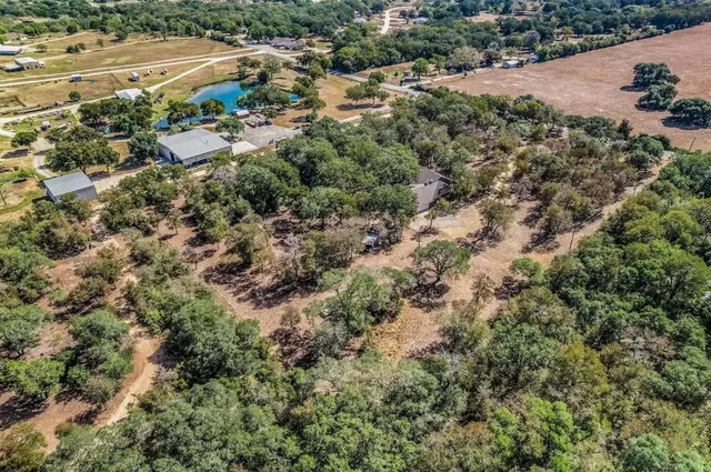 an aerial view of house with yard and mountain view in back