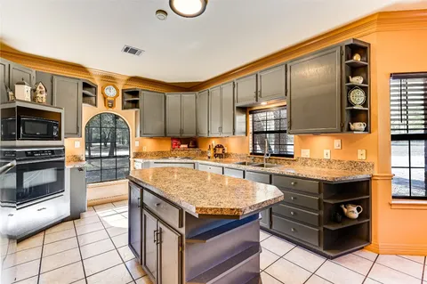 a kitchen with granite countertop a stove oven and a refrigerator
