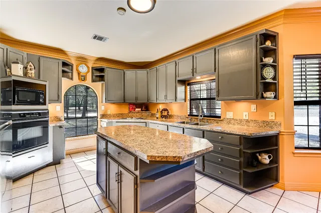 a kitchen with granite countertop a stove oven and a refrigerator