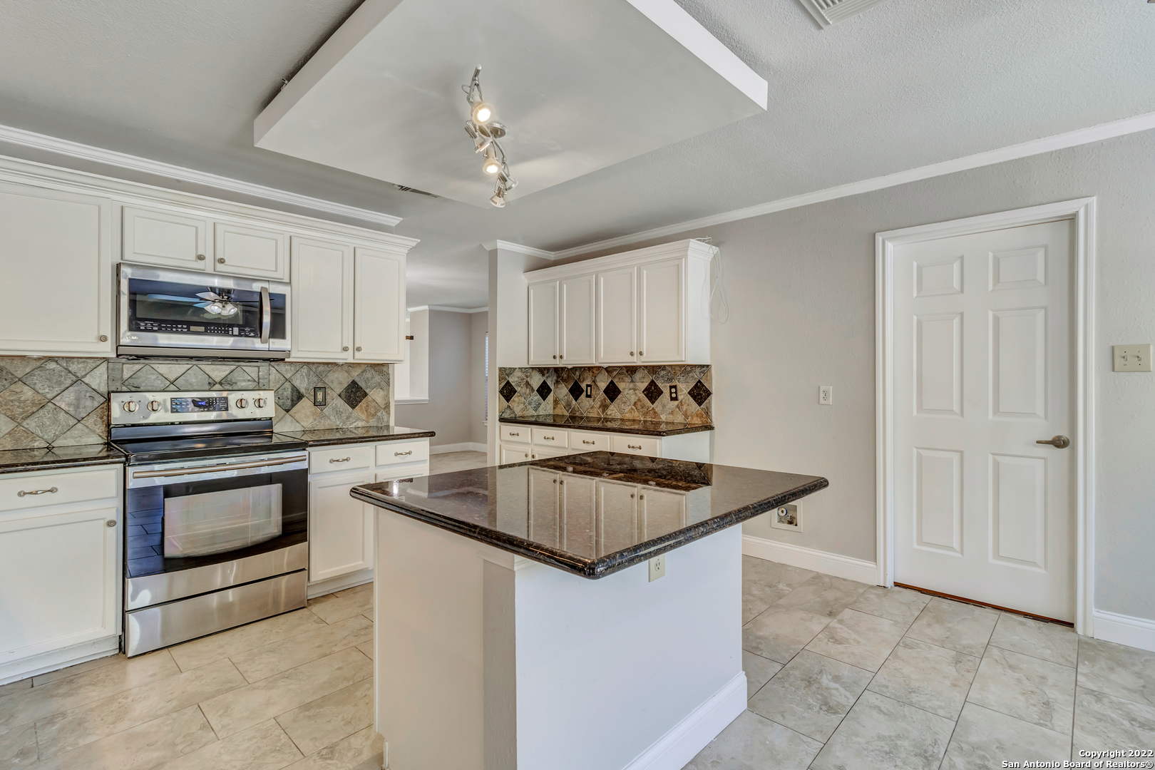 a kitchen with kitchen island granite countertop a stove sink and microwave