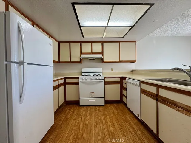 a kitchen with a white cabinets and wooden floor