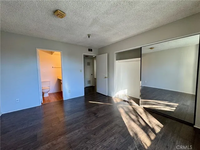 a bathroom with a granite countertop toilet sink and mirror