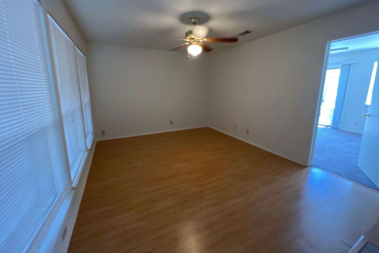 3115 Helms Street, Unit 111 Austin, TX 78705 - Photo 8 of 13 A versatile living space with elegant wood flooring and natural light, ready for personalization.