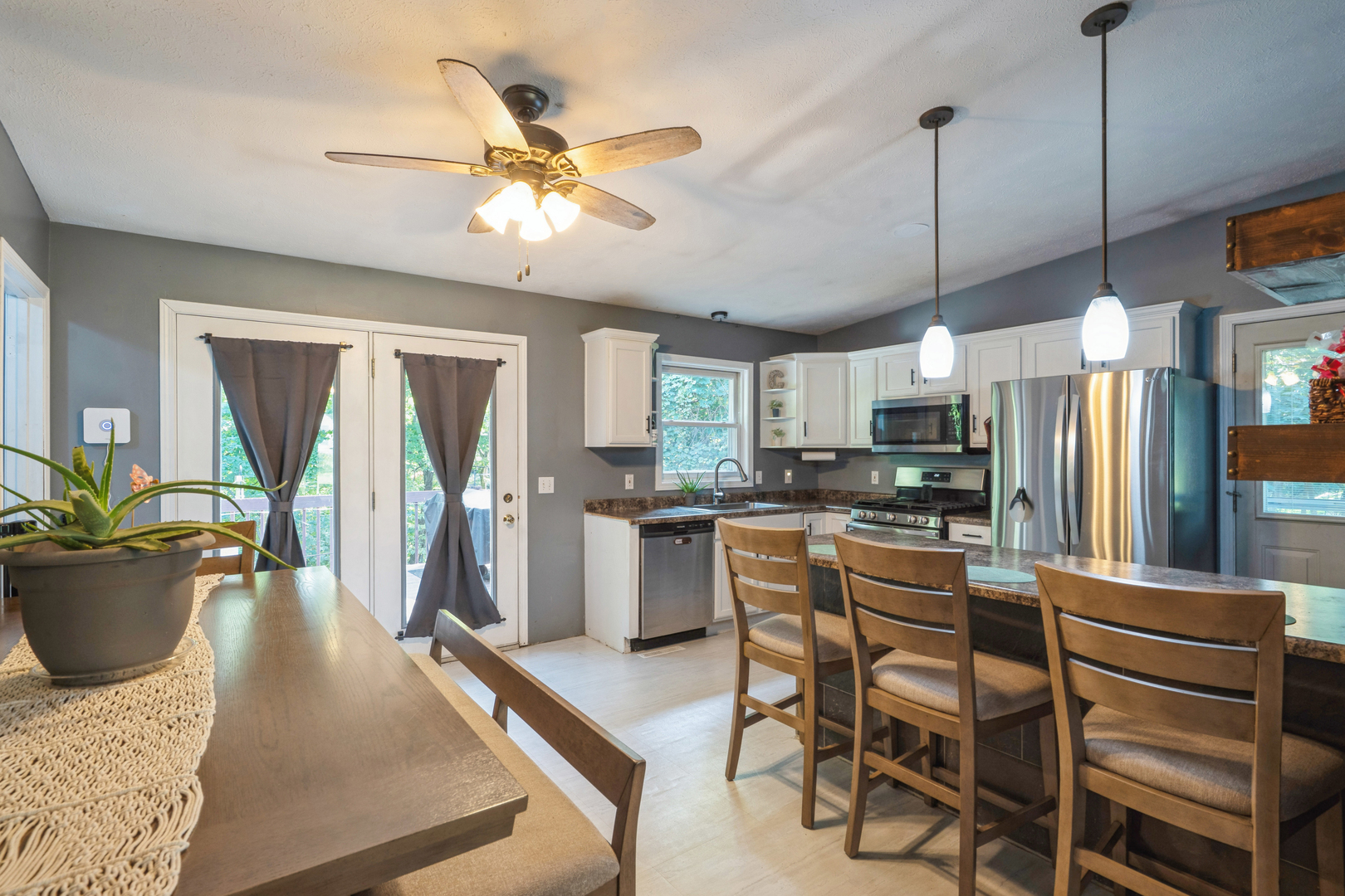 5444 10th Avenue Moline, IL 61265 - Photo 6 of 20 a kitchen with stainless steel appliances granite countertop a refrigerator a stove a sink dishwasher a dining table and chairs with wooden floor