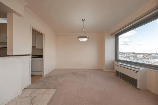 a view of a livingroom with a chandelier fan and windows