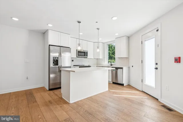 a kitchen with white cabinets and stainless steel appliances
