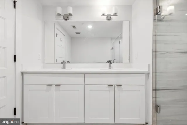 a bathroom with a sink vanity and a mirror