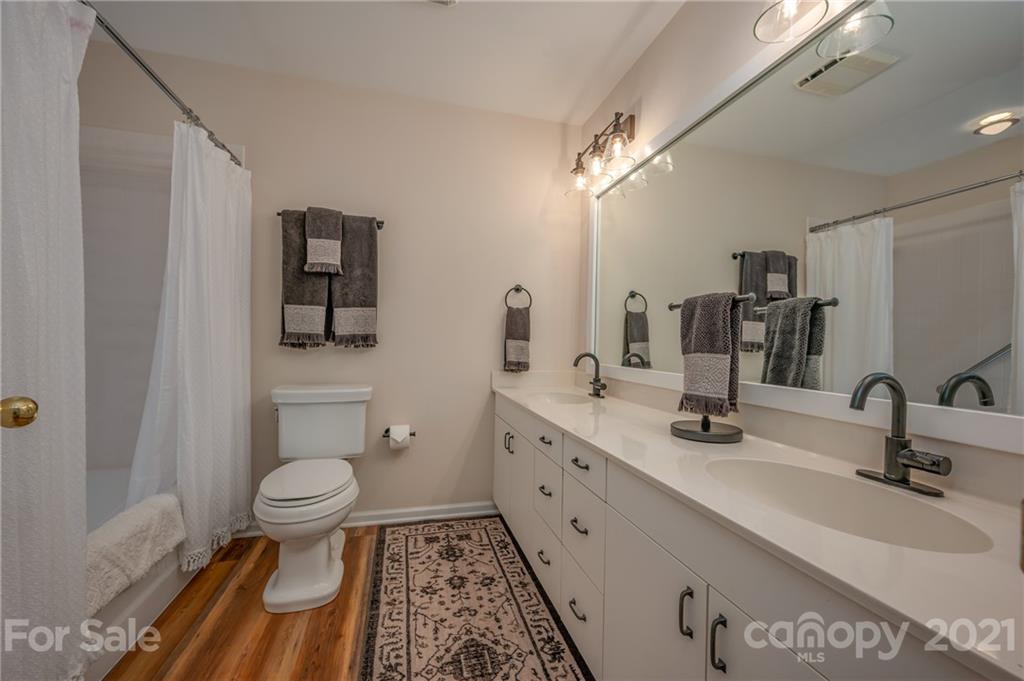 33 Hunting Country Trail Tryon, NC 28782 - Photo 14 of 34 a bathroom with a sink toilet a mirror and shower