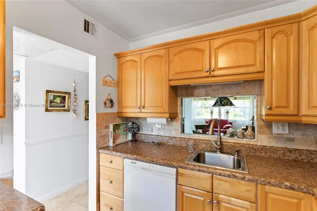 a kitchen with granite countertop a sink cabinets and window