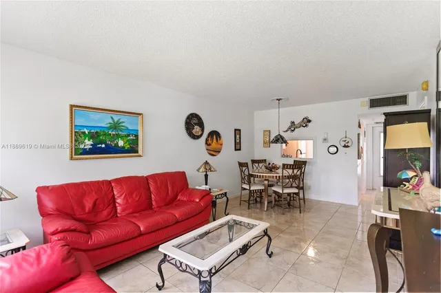 a living room with furniture a dining table and a window