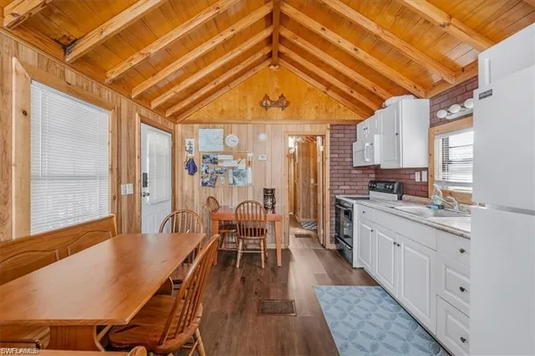 a dining room with stainless steel appliances furniture and a kitchen view