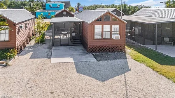 a view of a brick house with floor to ceiling windows and yard