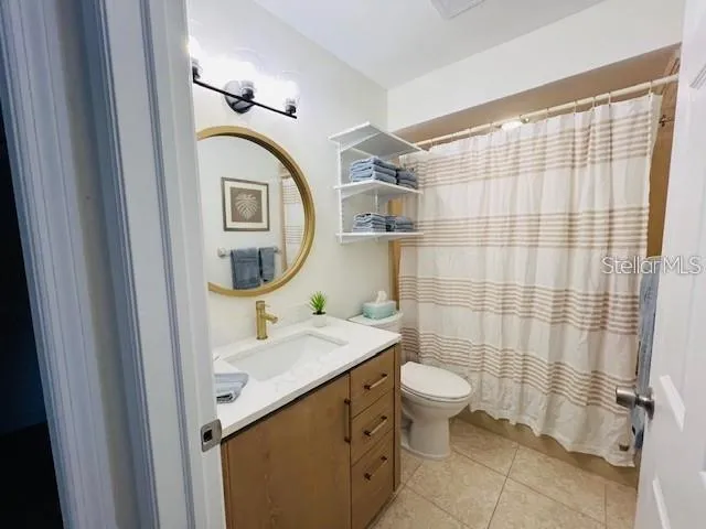 a bathroom with a sink a toilet and shower curtain